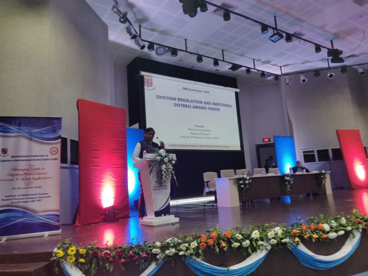 Dr Krishna Kumar Mishra at the lectern, his title slide ‘Emotion regulation and emotional distress among youth’ on the screen behind