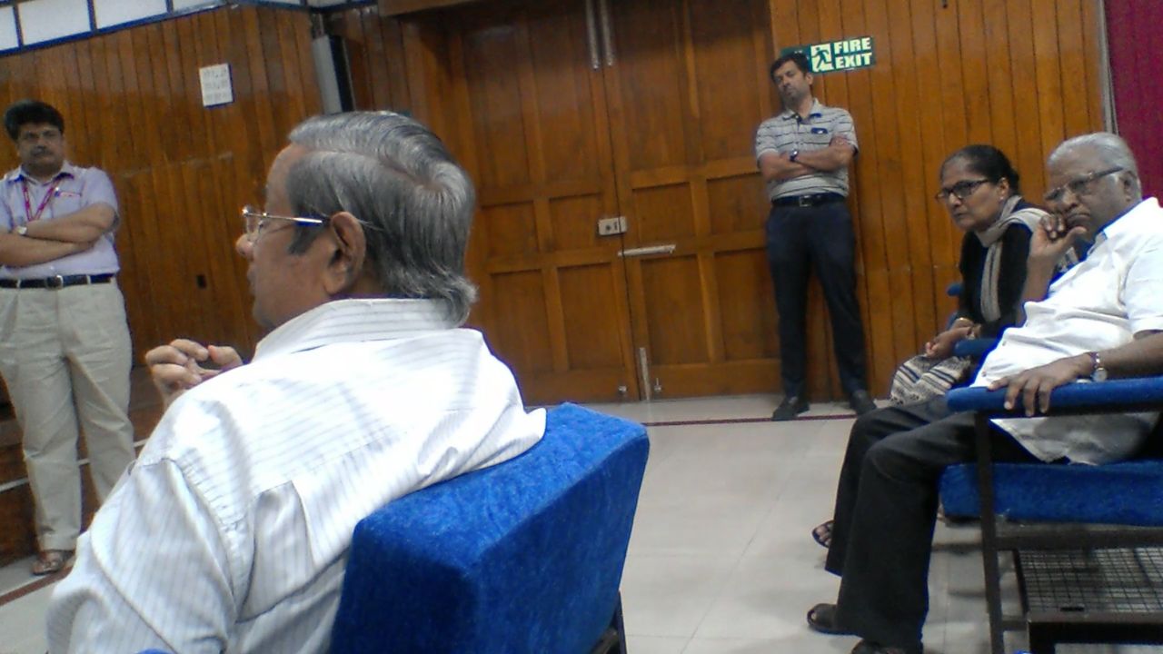 The front rows during the discussion, a seated man gesturing as he speaks